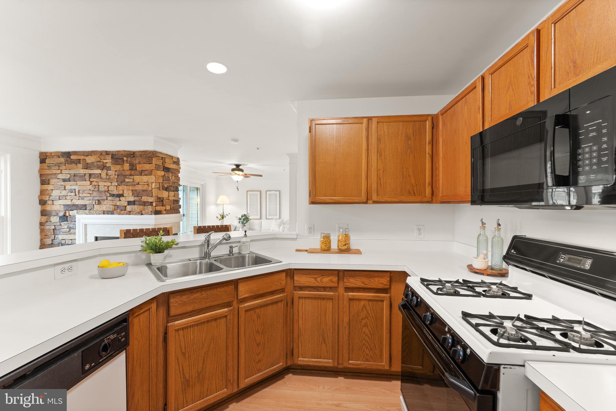 21777 Baldwin Square, Unit 301 Sterling, VA 20164 - Photo 11 of 33 a kitchen with a sink stove top oven and cabinets