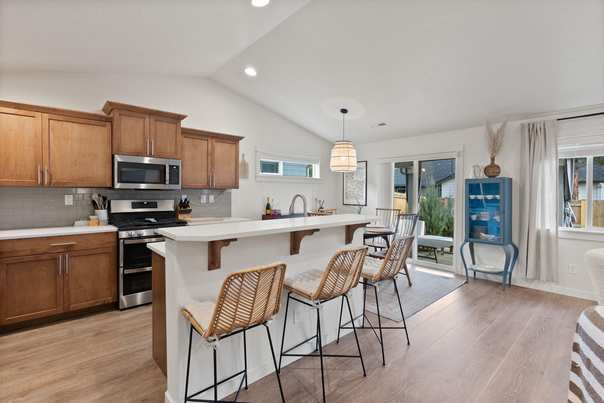 632 North Reed Street Sisters, OR 97759 - Photo 9 of 36 a kitchen with stainless steel appliances granite countertop a stove top oven a sink dishwasher a dining table and chairs with wooden floor