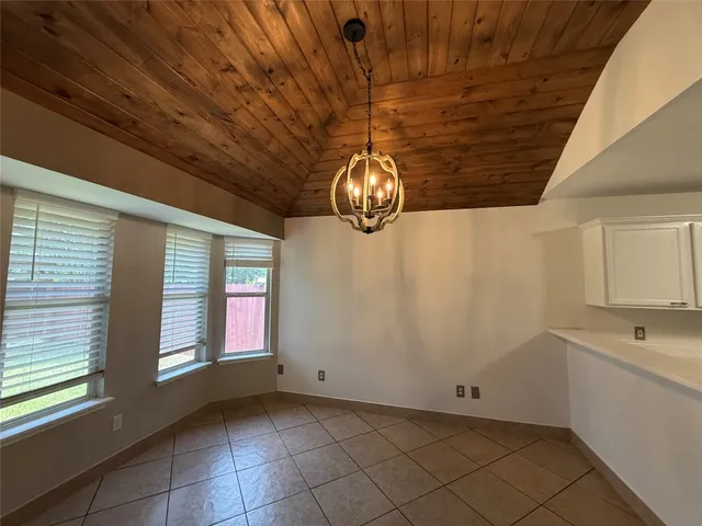a view of kitchen with granite countertop window and cabinets
