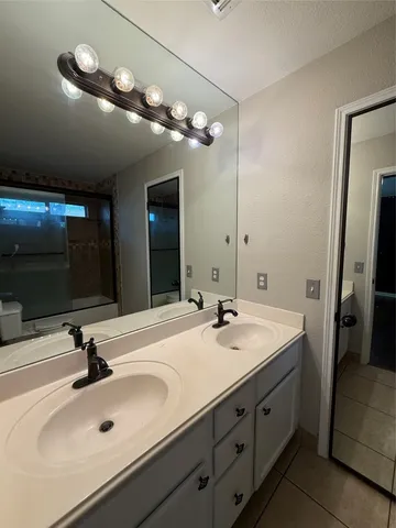 a bathroom with a sink double vanity and a mirror