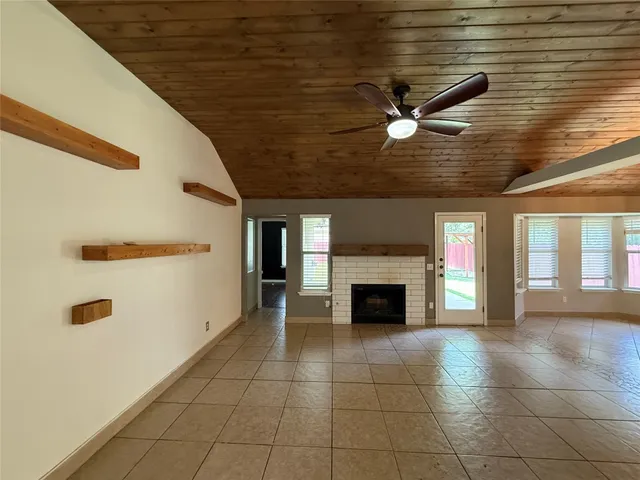 a view of an empty room with a fireplace and a window