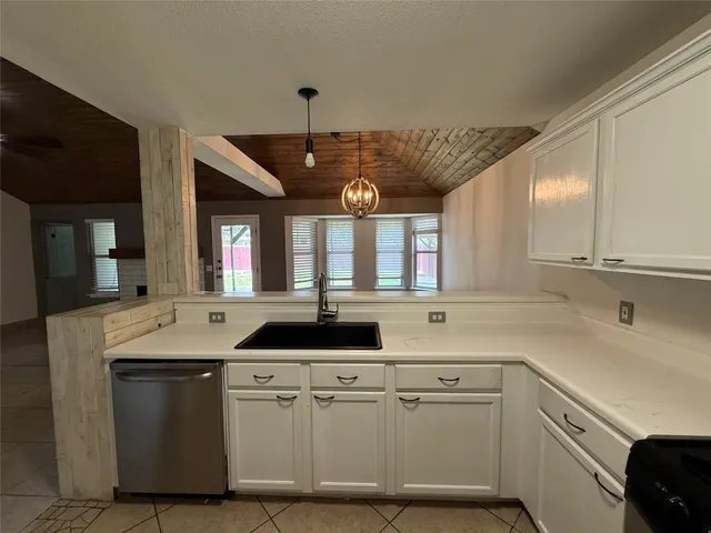 a kitchen with a sink cabinets and window