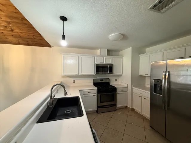a kitchen with stainless steel appliances a refrigerator sink and microwave