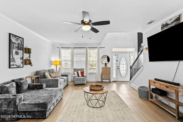 a living room with furniture a flat screen tv and a window