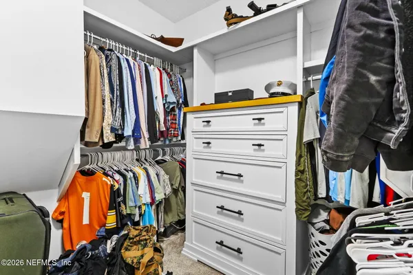 a view of walk in closet with clothes and shoes
