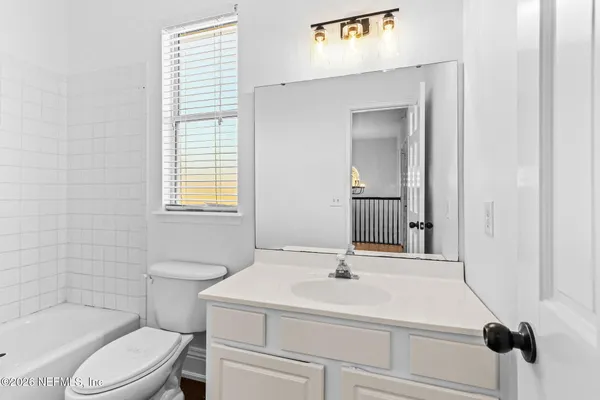 a bathroom with a sink toilet vanity and tub