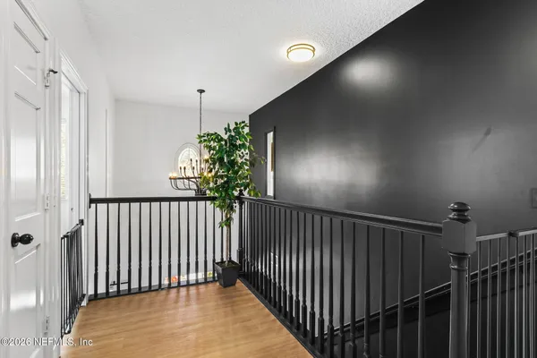 a view of staircase with railing and a chandelier