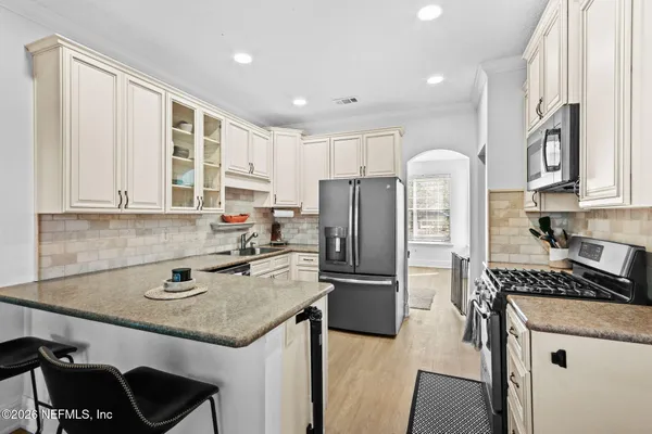 a kitchen with stainless steel appliances granite countertop a sink stove and refrigerator