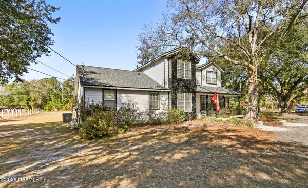 a front view of a house with a yard and trees