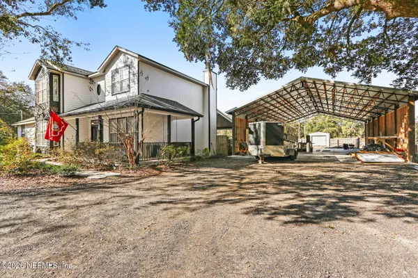 a view of a white house with a large windows and palm trees