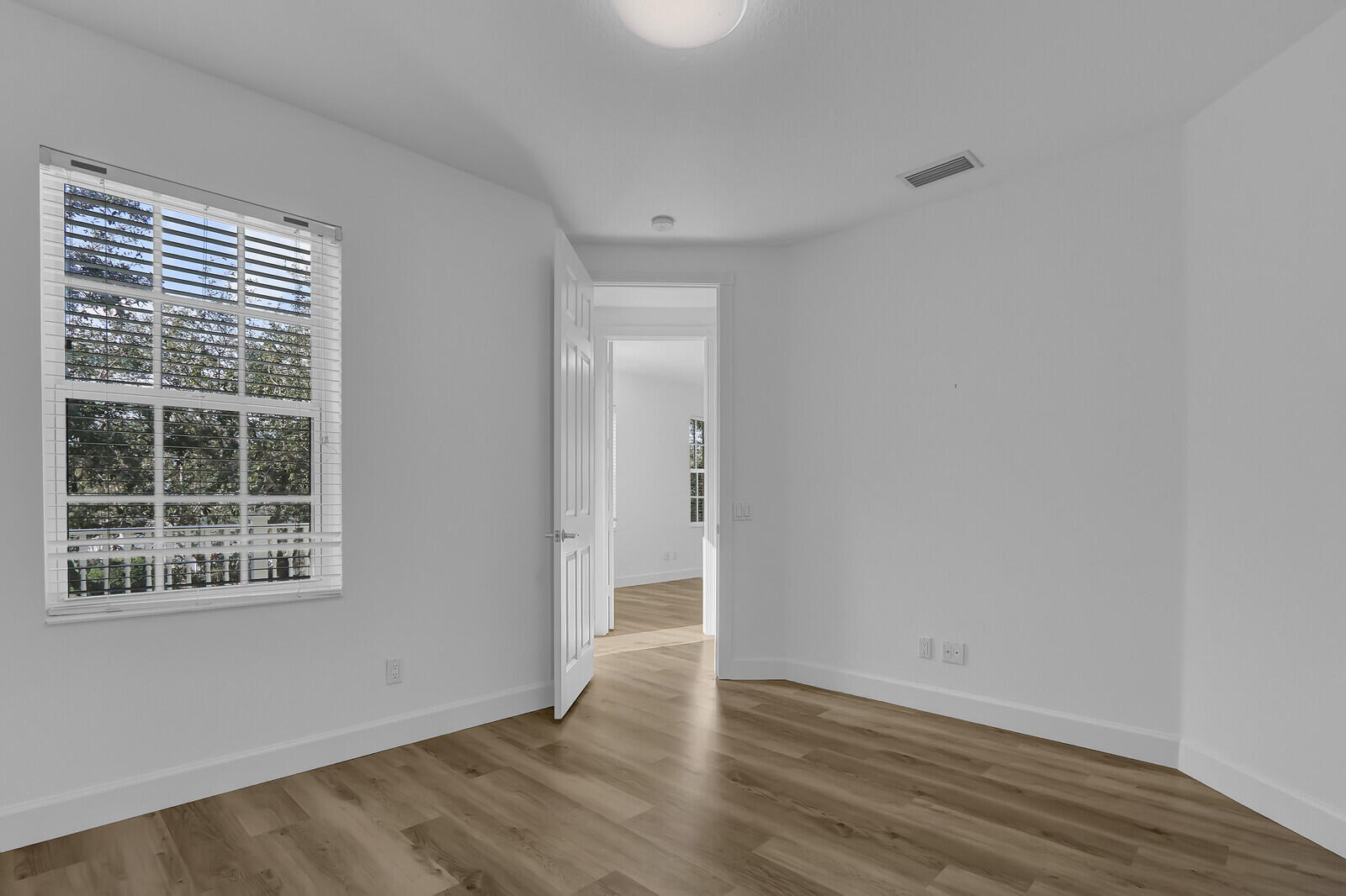 199 Barbados Drive Jupiter, FL 33458 - Photo 28 of 38 a view of an empty room with wooden floor and a window