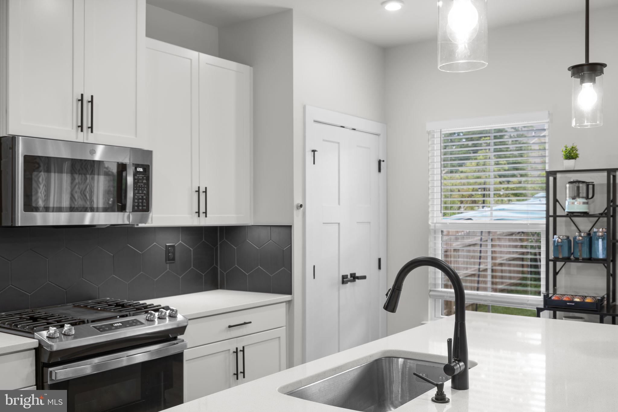 1713 Aurora Way Frederick, MD 21702 - Photo 19 of 57 a kitchen with granite countertop a stove a sink and a microwave