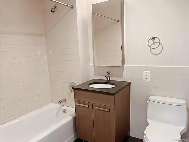 a bathroom with a granite countertop sink toilet and bathtub