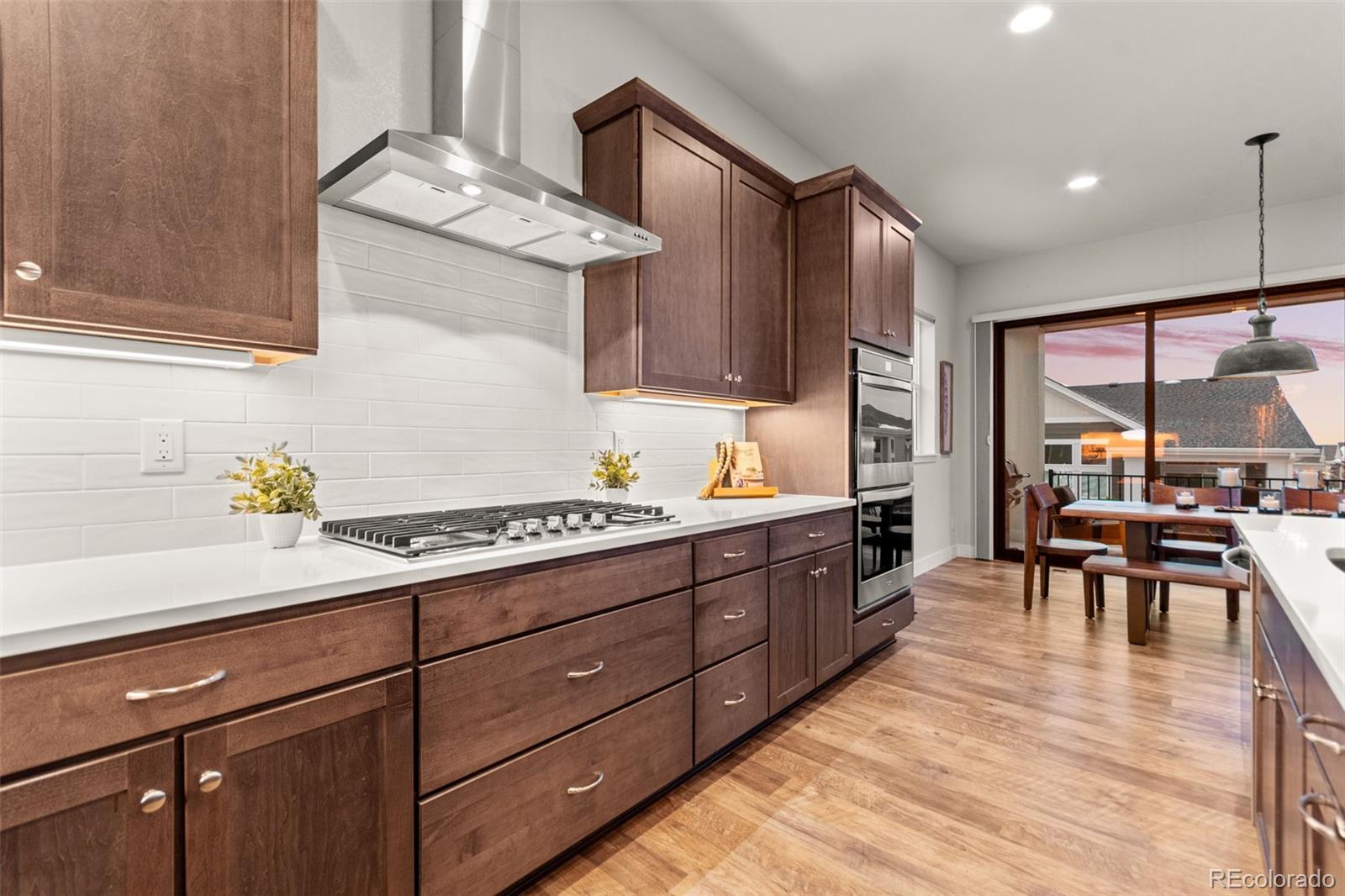9388 Dunraven Loop Arvada, CO 80007 - Photo 12 of 50 a kitchen with stainless steel appliances granite countertop a sink stove and cabinets