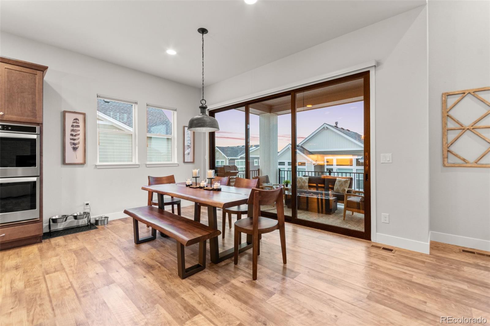 9388 Dunraven Loop Arvada, CO 80007 - Photo 15 of 50 a dining room with wooden floor a glass table and chairs