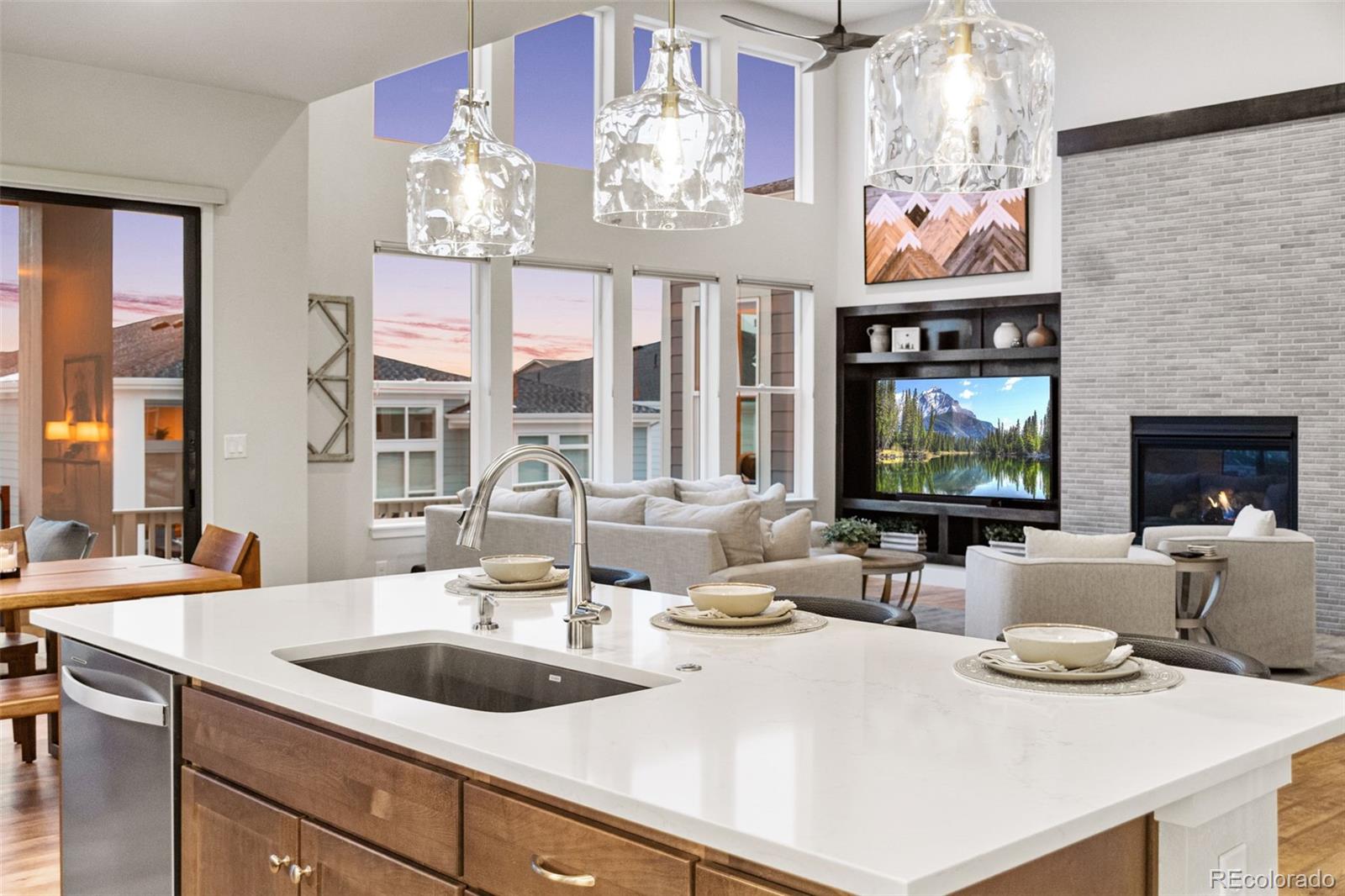 9388 Dunraven Loop Arvada, CO 80007 - Photo 22 of 50 a view of a dining room with furniture a chandelier and kitchen view