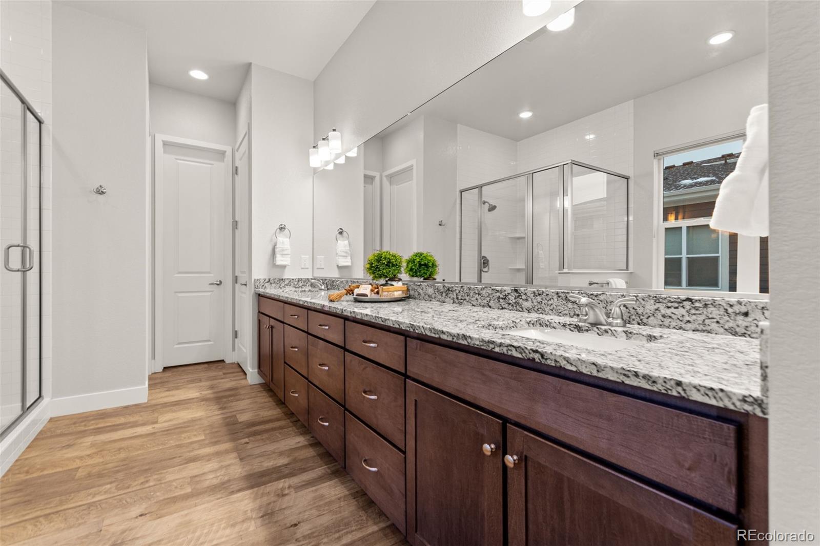 9388 Dunraven Loop Arvada, CO 80007 - Photo 34 of 50 a bathroom with a granite countertop double vanity sink and a mirror