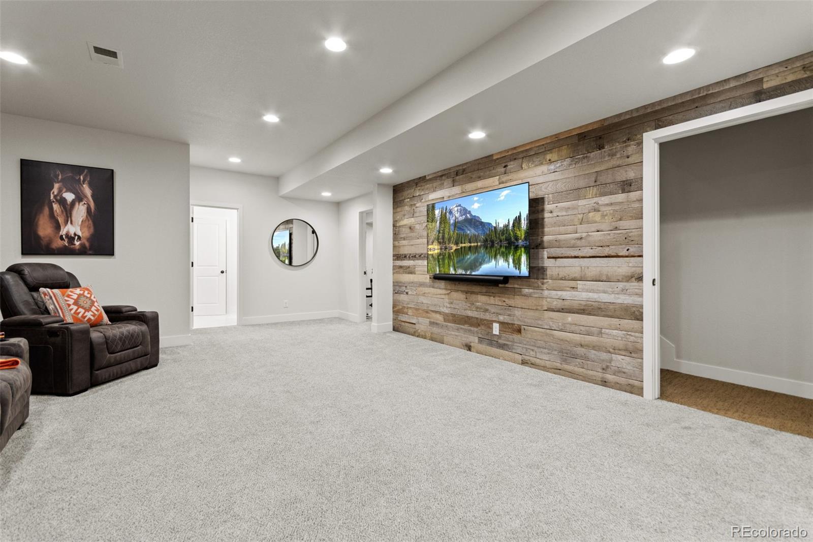 9388 Dunraven Loop Arvada, CO 80007 - Photo 36 of 50 a living room with furniture and a flat screen tv
