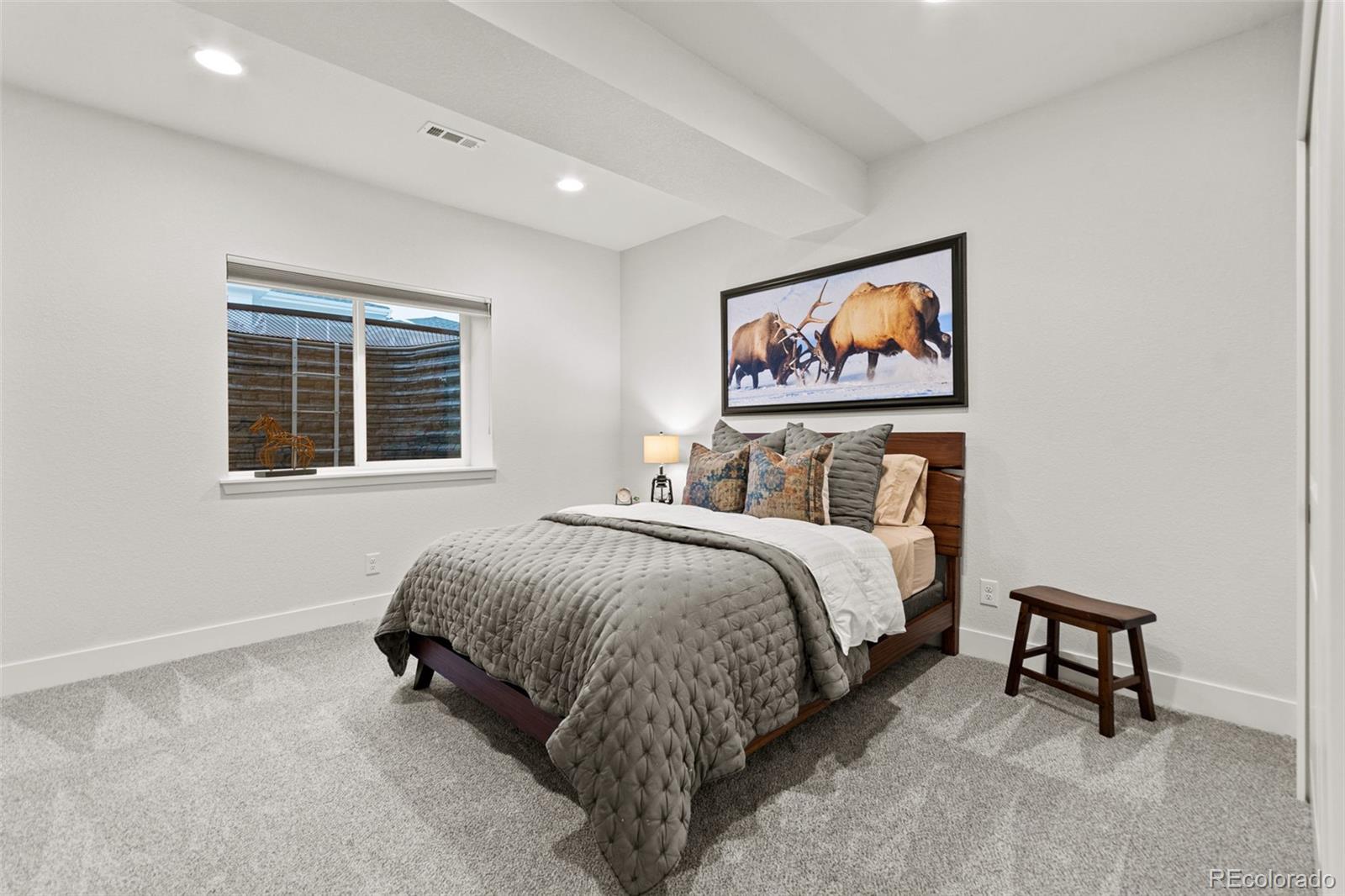 9388 Dunraven Loop Arvada, CO 80007 - Photo 41 of 50 a spacious bedroom with a bed and a window