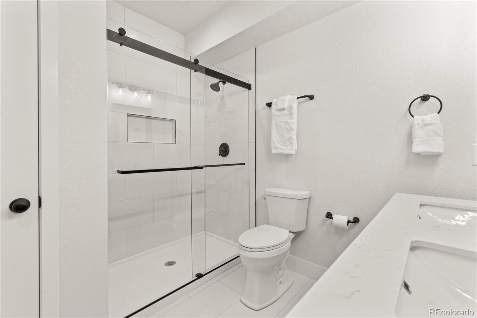 9388 Dunraven Loop Arvada, CO 80007 - Photo 42 of 50 a white toilet sitting next to a bathroom sink