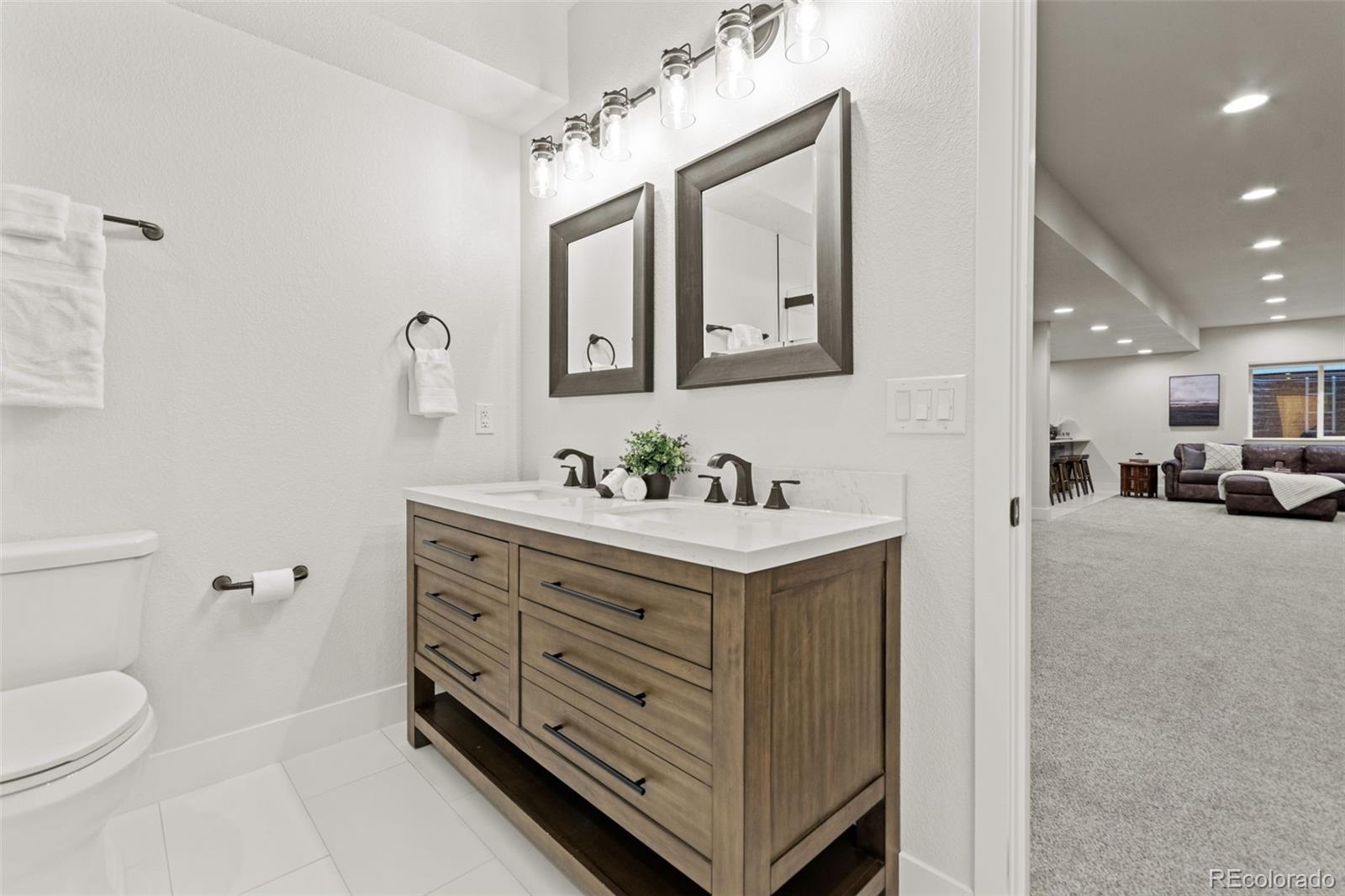 9388 Dunraven Loop Arvada, CO 80007 - Photo 43 of 50 a view of bathroom with a sink mirror and toilet