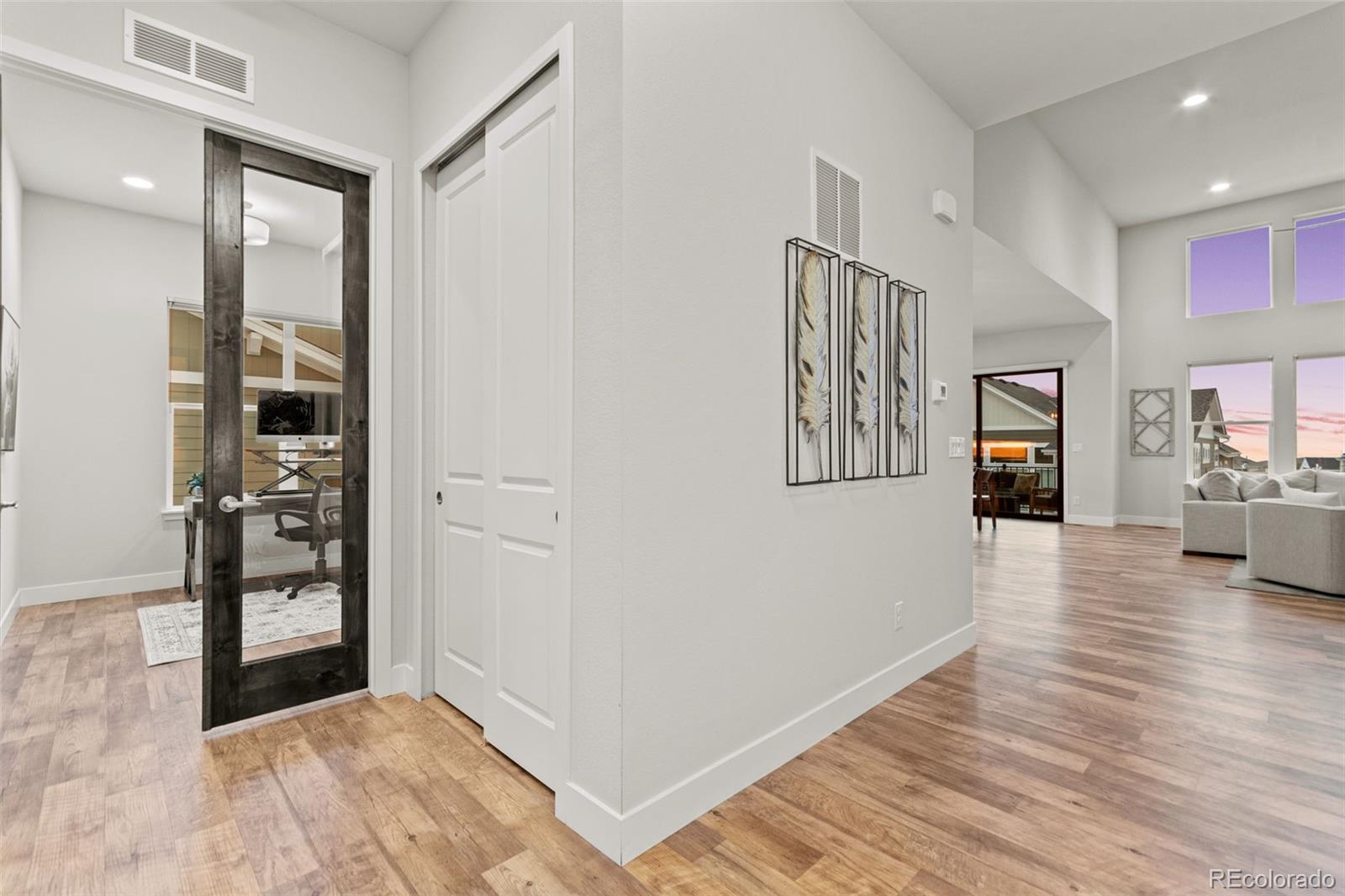 9388 Dunraven Loop Arvada, CO 80007 - Photo 5 of 50 a view of a hallway with wooden floor and windows