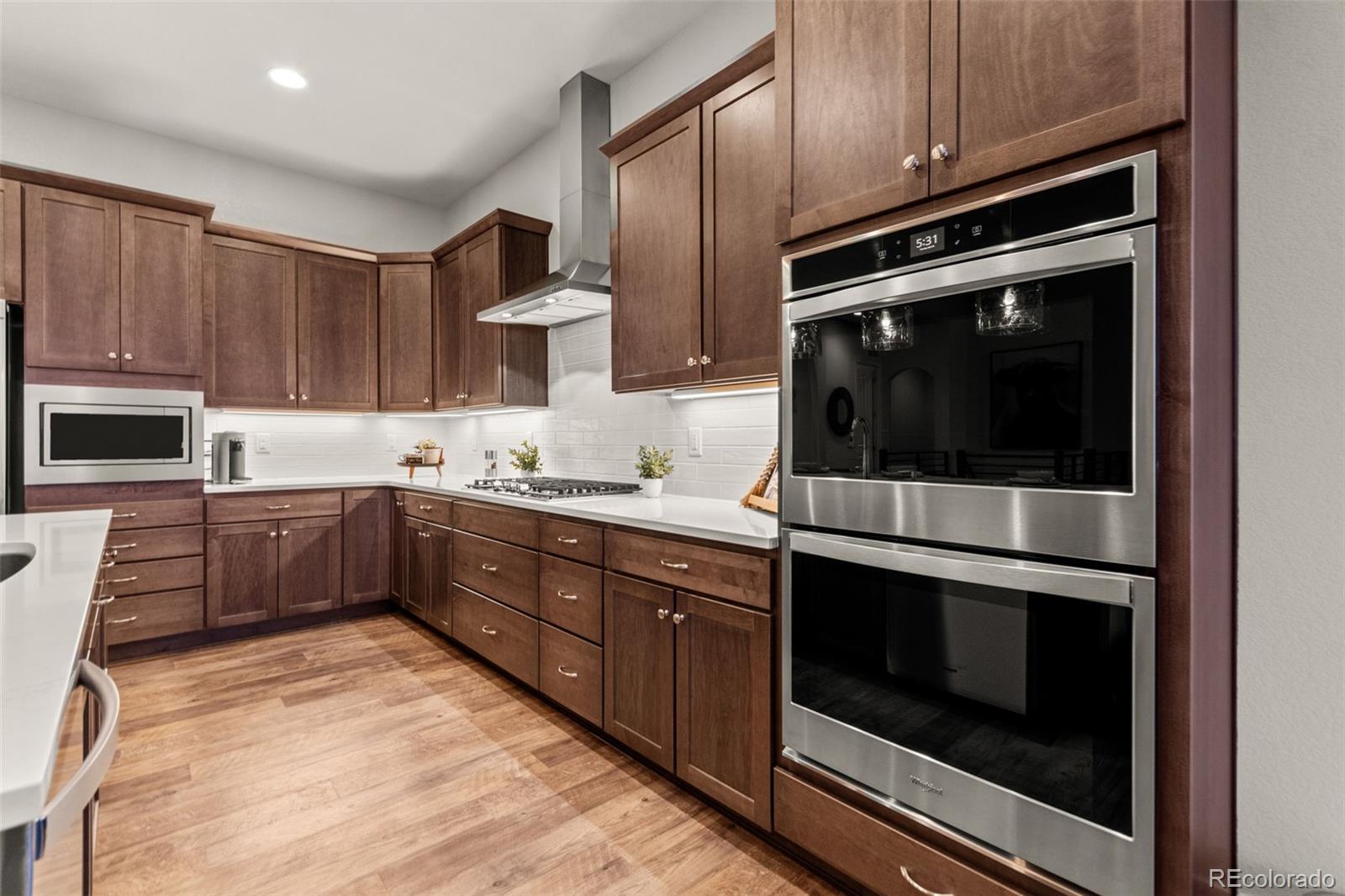 9388 Dunraven Loop Arvada, CO 80007 - Photo 9 of 50 a kitchen with stainless steel appliances kitchen island granite countertop a stove microwave and cabinets