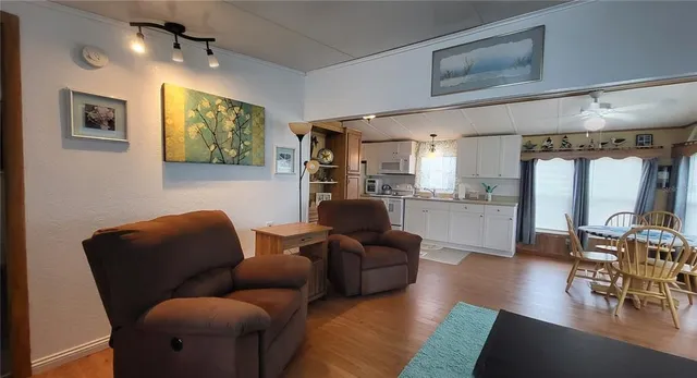 a living room with furniture and a view of kitchen
