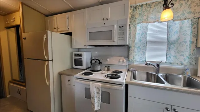 a kitchen with a refrigerator and a stove