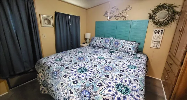 a bedroom with a bed and a painting on the wall