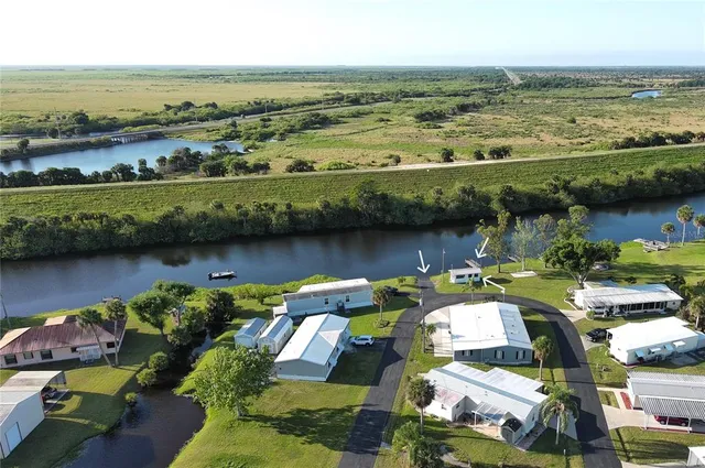 an aerial view of ocean and residential houses with outdoor space