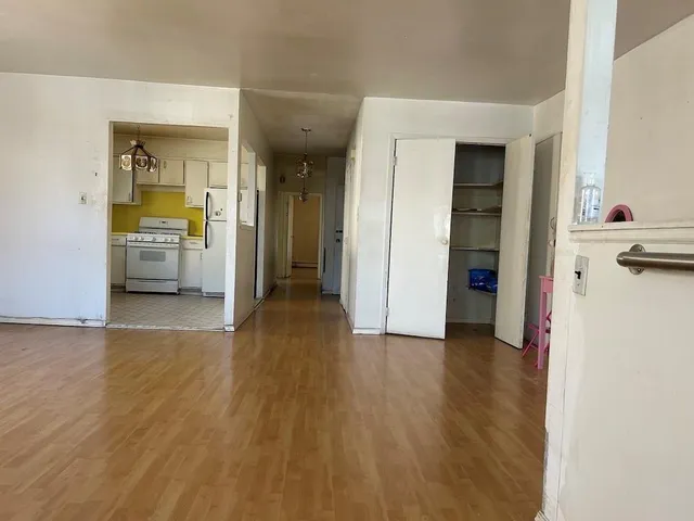 a view of a kitchen with a refrigerator and a stove top oven