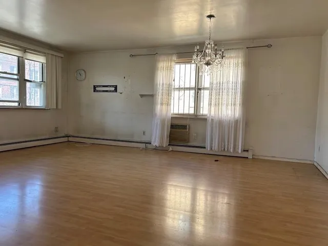 a view of a room with wooden floor and a window