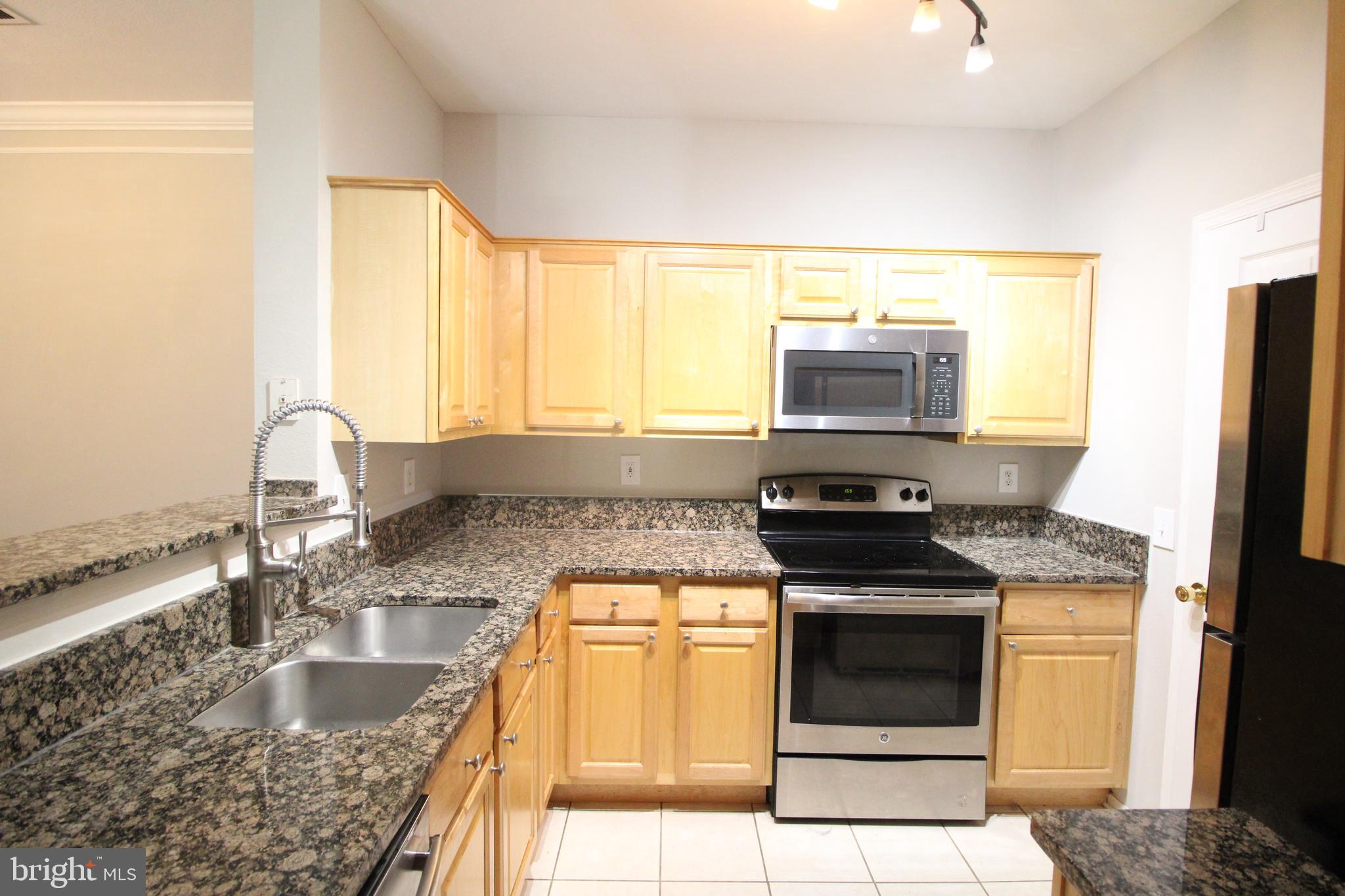 1570 Spring Gate Dr., Unit 7108 McLean, VA 22102 - Photo 1 of 21 a kitchen with granite countertop a sink stainless steel appliances and a counter top space