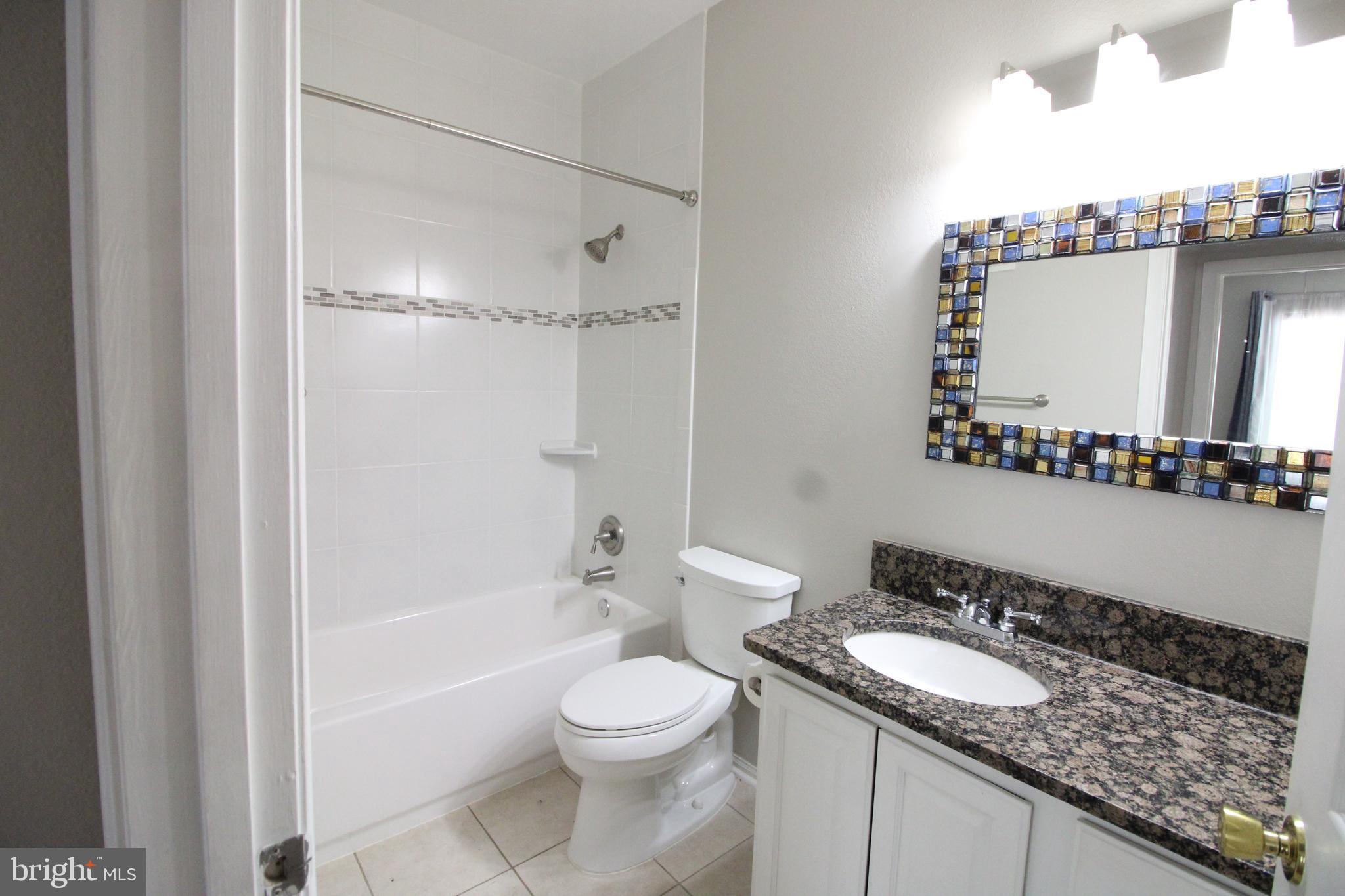 1570 Spring Gate Dr., Unit 7108 McLean, VA 22102 - Photo 14 of 21 a bathroom with a granite countertop sink toilet mirror and shower