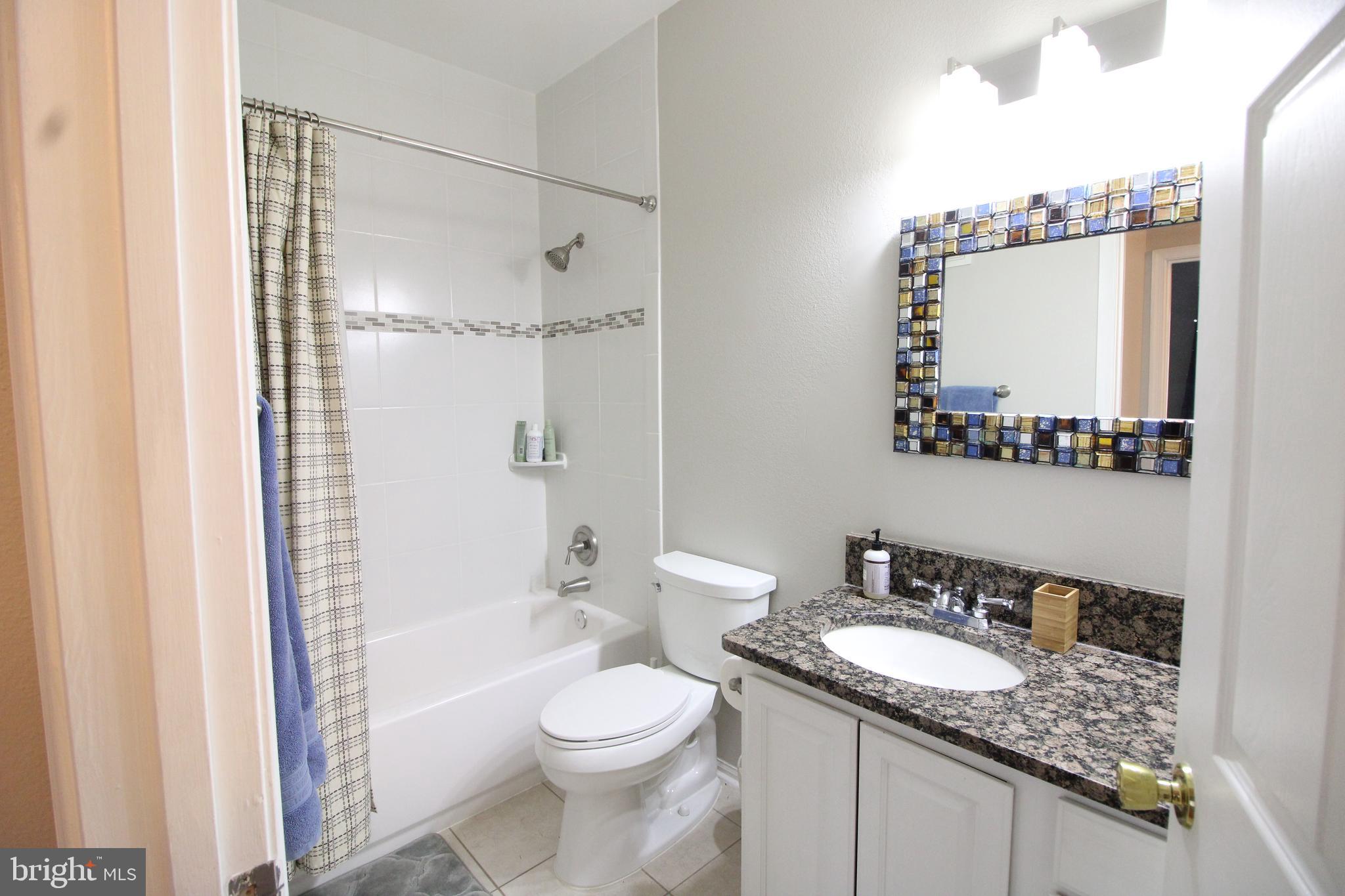 1570 Spring Gate Dr., Unit 7108 McLean, VA 22102 - Photo 19 of 21 a bathroom with a granite countertop sink toilet mirror and shower