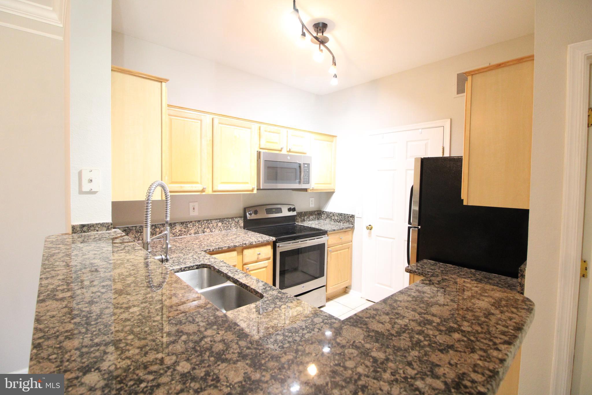 1570 Spring Gate Dr., Unit 7108 McLean, VA 22102 - Photo 5 of 21 a kitchen with sink and refrigerator
