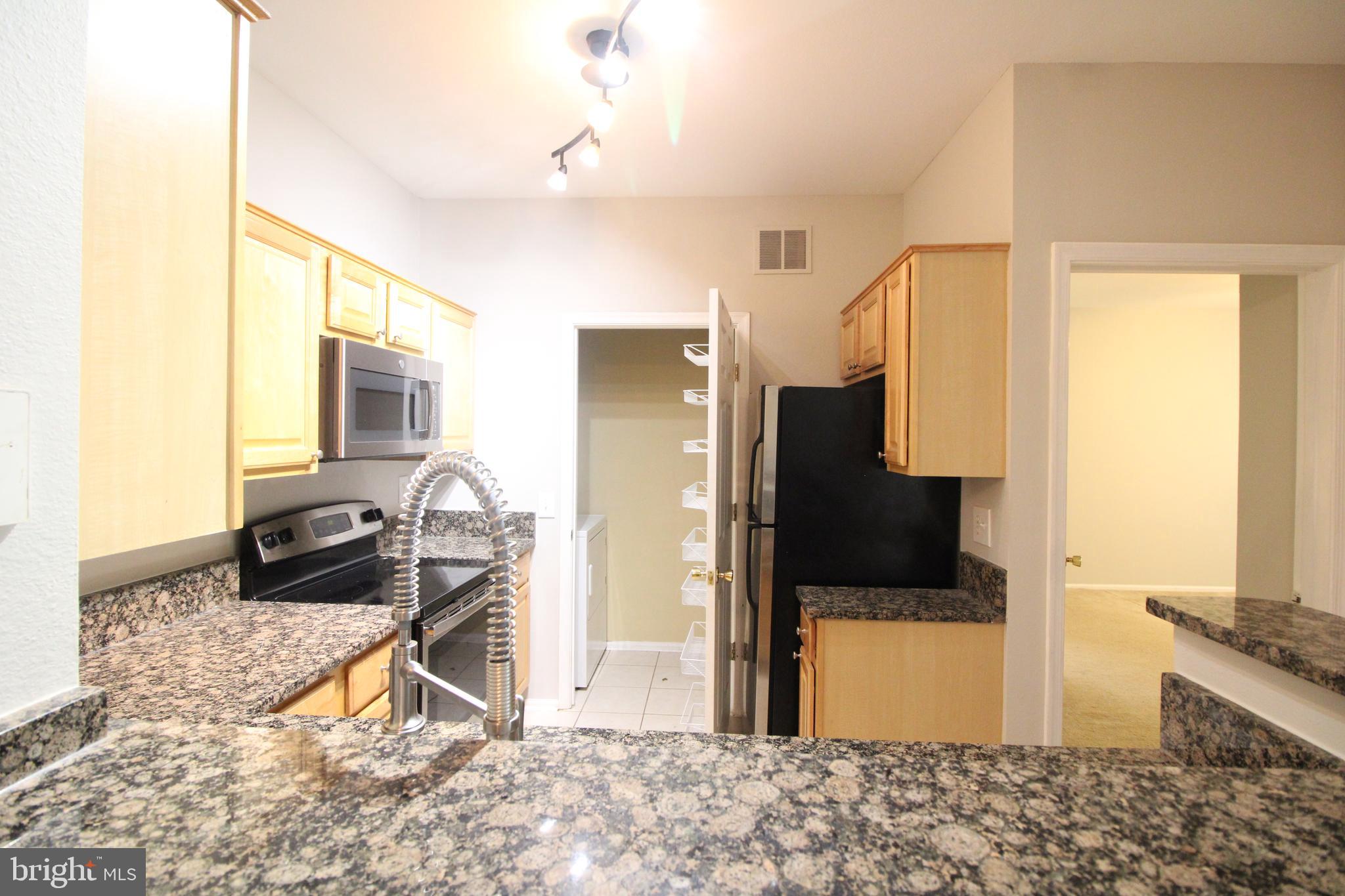 1570 Spring Gate Dr., Unit 7108 McLean, VA 22102 - Photo 7 of 21 a living room with a flat screen tv and a stove