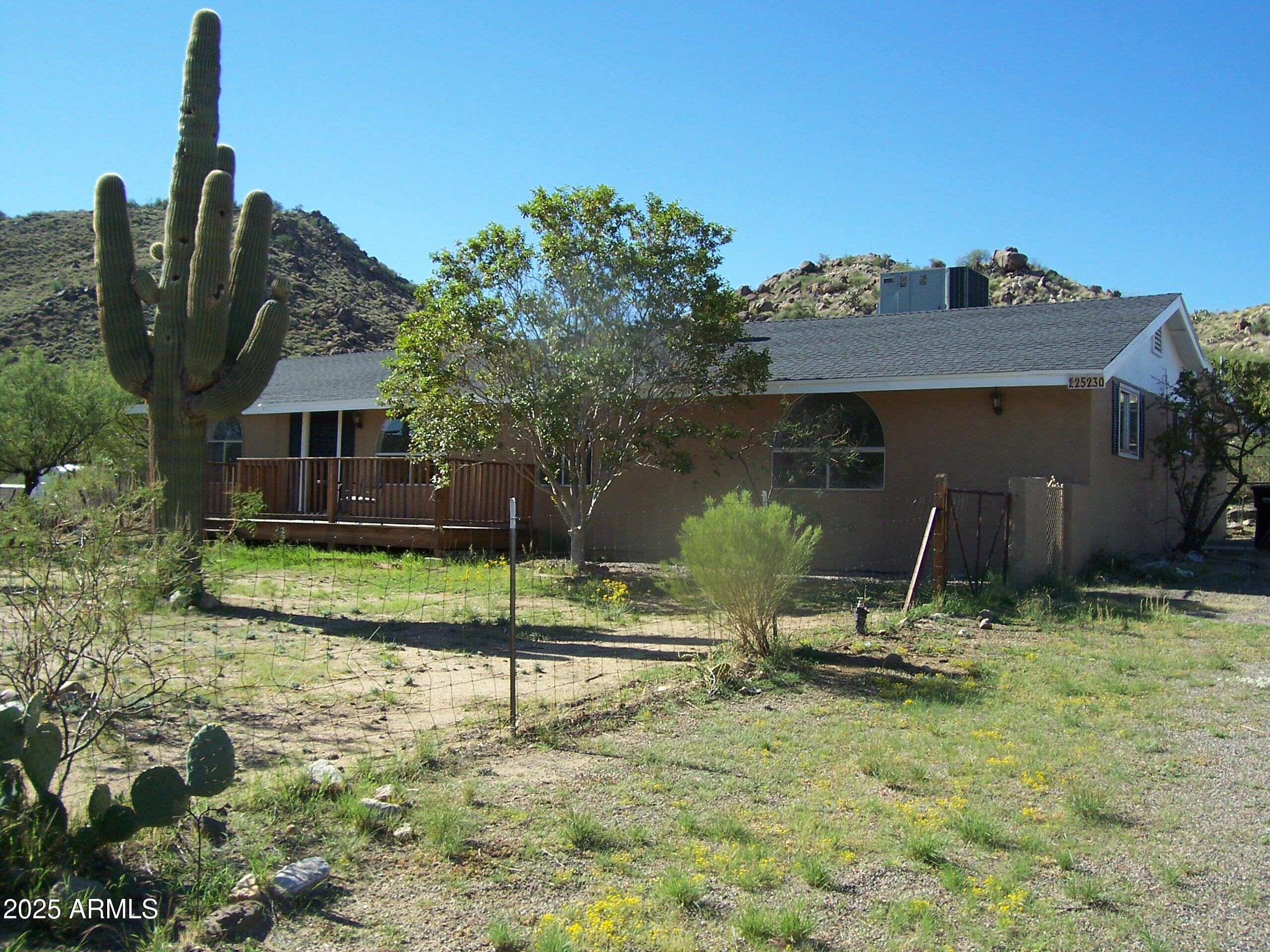 a view of a house with backyard and a tree