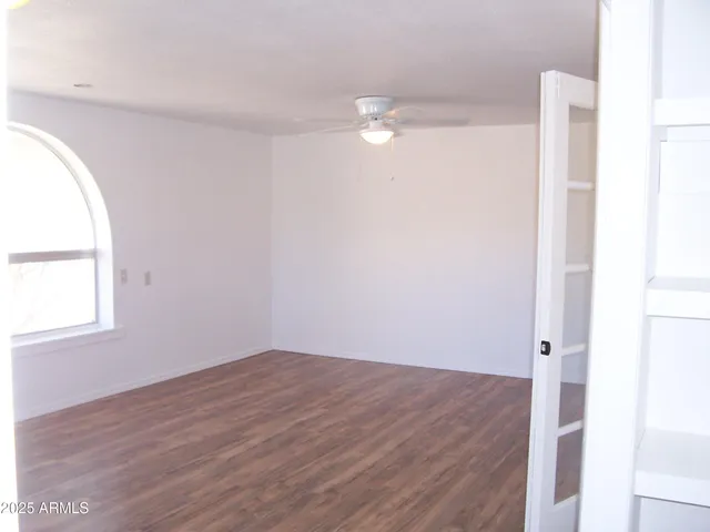 an empty room with wooden floor and window