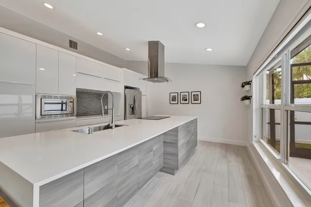 a large kitchen with a large counter top appliances and cabinets