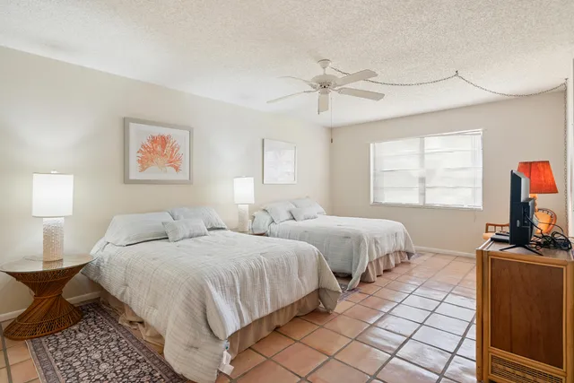 a bedroom with two beds and a flat screen tv