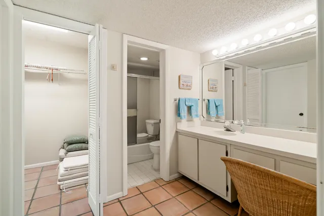 a bathroom with a sink and mirror with toilet