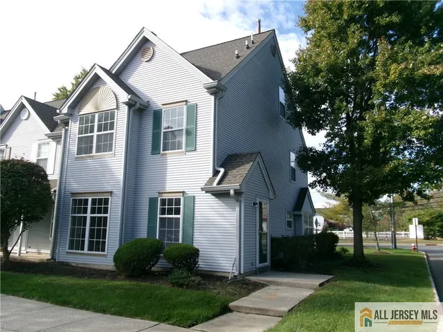 a front view of a house with a yard and trees