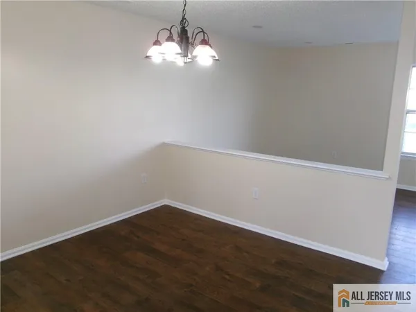 a view of a big room with wooden floor and chandelier
