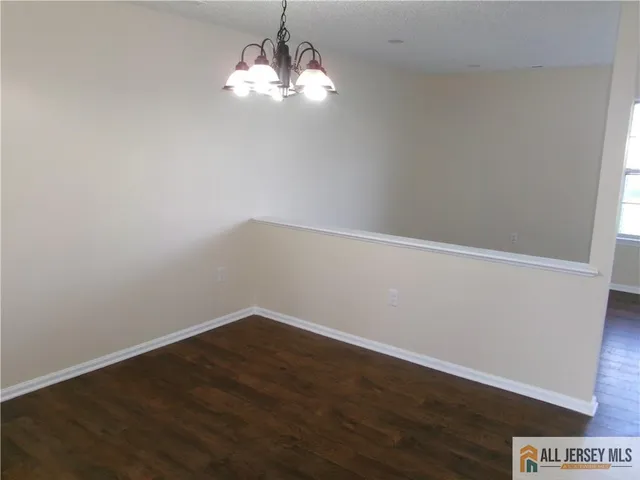 a view of a big room with wooden floor and chandelier
