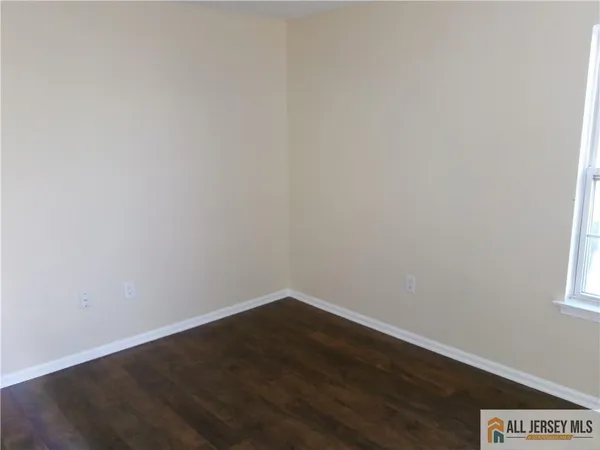 a view of a small space with wooden floor and a window