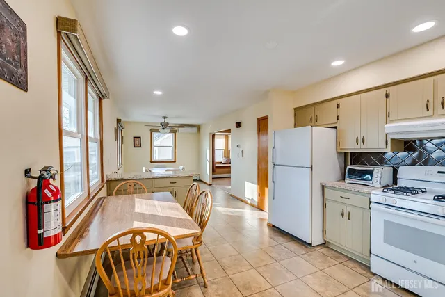 a very nice looking open kitchen with stainless steel appliances granite countertop a refrigerator and a stove top oven