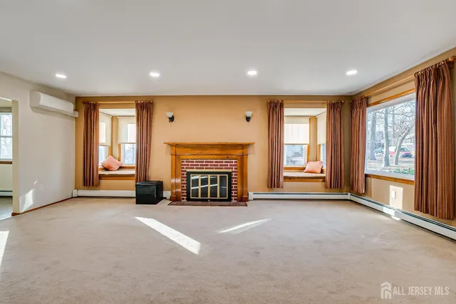 a view of an empty room with a fireplace and a window