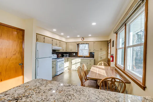 a kitchen with stainless steel appliances granite countertop a refrigerator and a sink